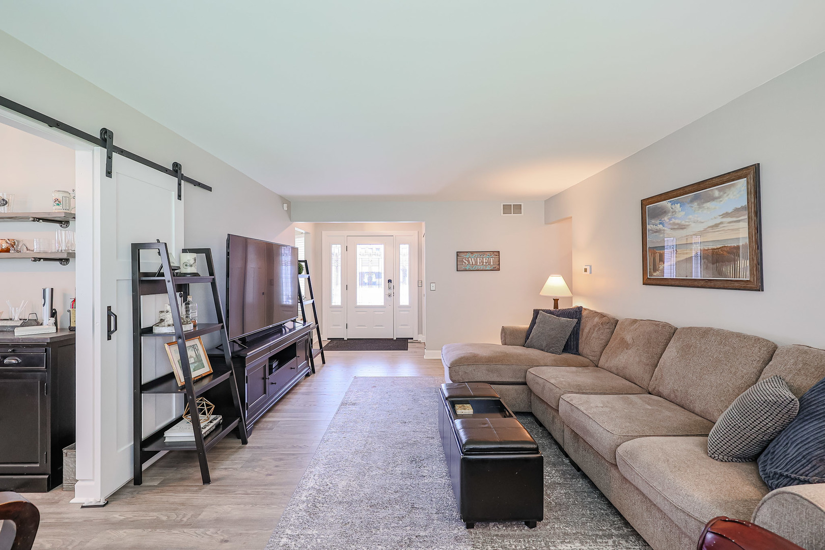 135 Cinderford Drive Oswego, IL 60543 - Photo 6 of 32 a living room with furniture a flat screen tv and a window