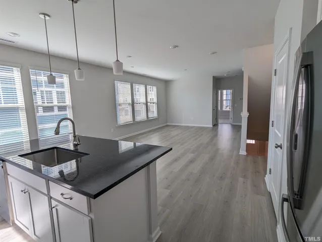 a kitchen with stainless steel appliances granite countertop a sink and wooden floor