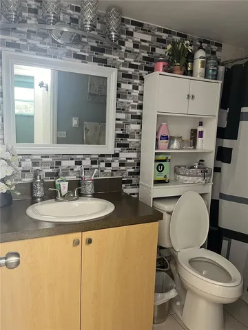 a white toilet sitting next to a bathroom sink