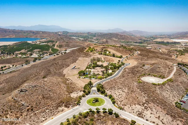 an aerial view of a house with a mountain