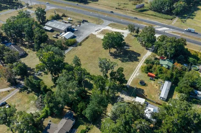 an aerial view of residential house with outdoor space and trees all around