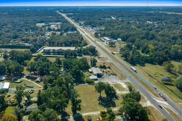 an aerial view of residential houses with outdoor space and lake view
