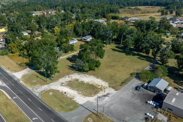 an aerial view of a houses with yard and mountain view