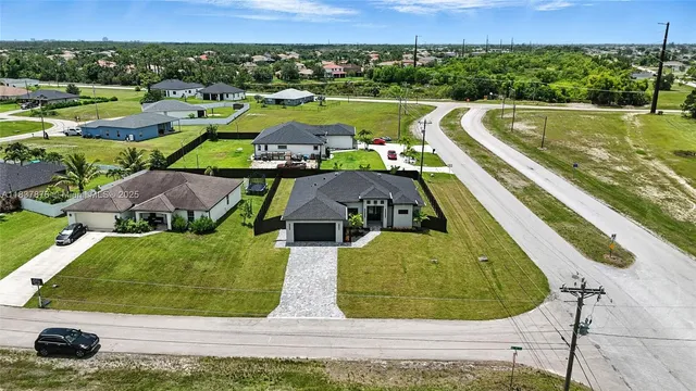 an aerial view of a residential houses with outdoor space and swimming pool
