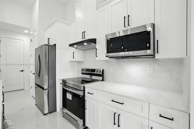 a kitchen with stainless steel appliances a stove microwave and refrigerator