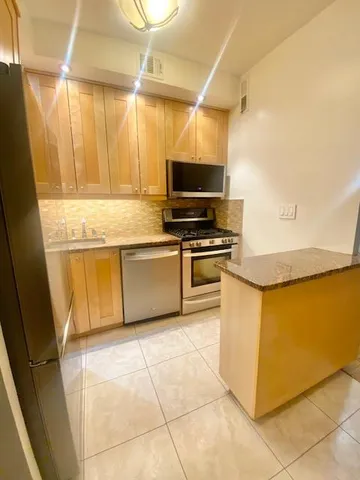 a kitchen with cabinets and steel appliances