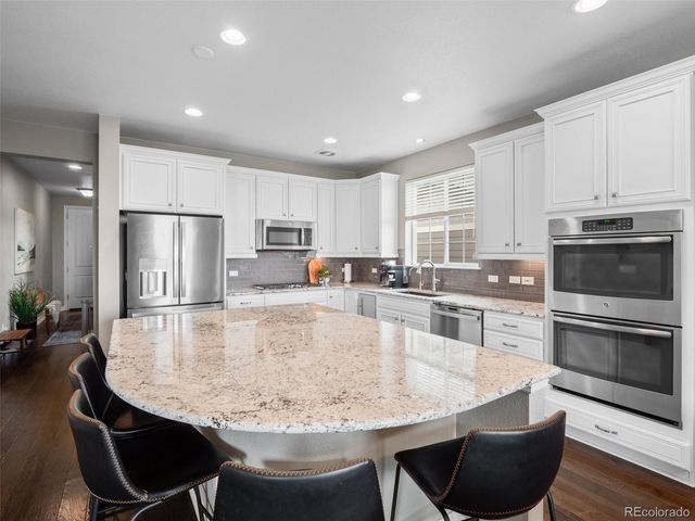 a large kitchen with kitchen island a table and chairs