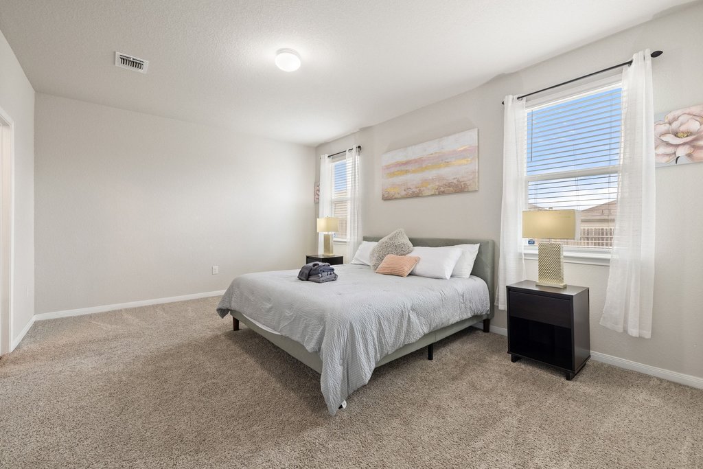 204 Rochester Lane Hutto, TX 78634 - Photo 21 of 40 Bedroom featuring light colored carpet and baseboards