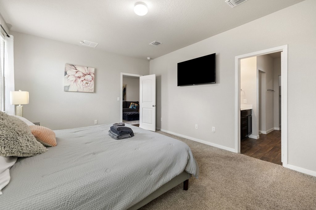 204 Rochester Lane Hutto, TX 78634 - Photo 22 of 40 Bedroom featuring dark carpet and ensuite bathroom