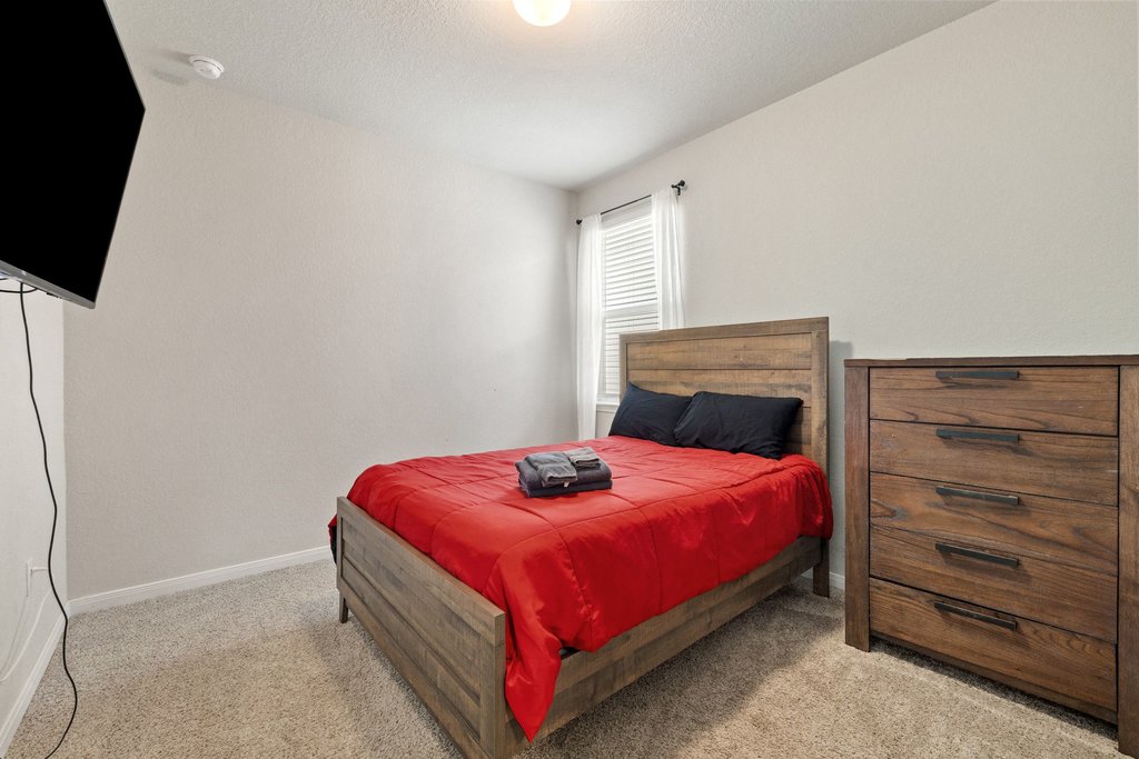 204 Rochester Lane Hutto, TX 78634 - Photo 31 of 40 Bedroom with light colored carpet and a textured ceiling
