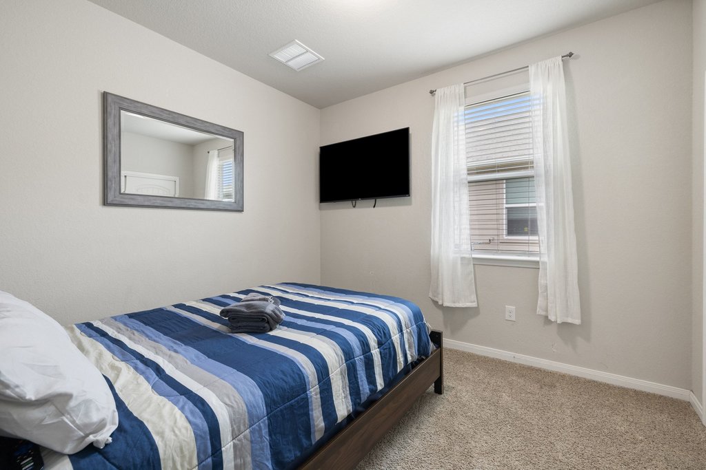 204 Rochester Lane Hutto, TX 78634 - Photo 32 of 40 Bedroom featuring light colored carpet and baseboards