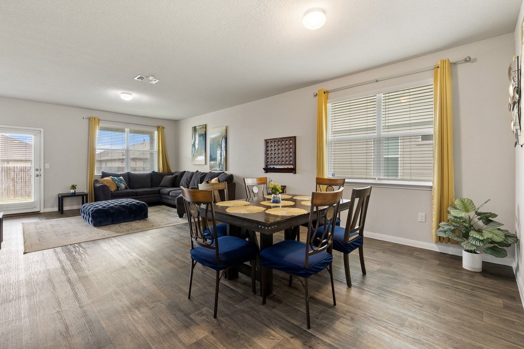 204 Rochester Lane Hutto, TX 78634 - Photo 7 of 40 Dining room with wood finished floors, healthy amount of natural light, and a textured ceiling