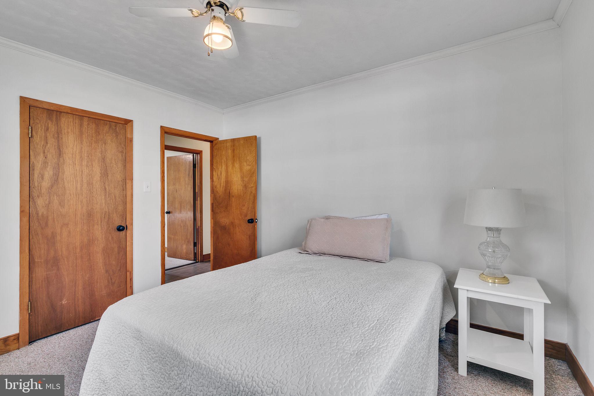 239 Lane Road Reedville, VA 22539 - Photo 19 of 61 a bedroom with a bed and a chandelier