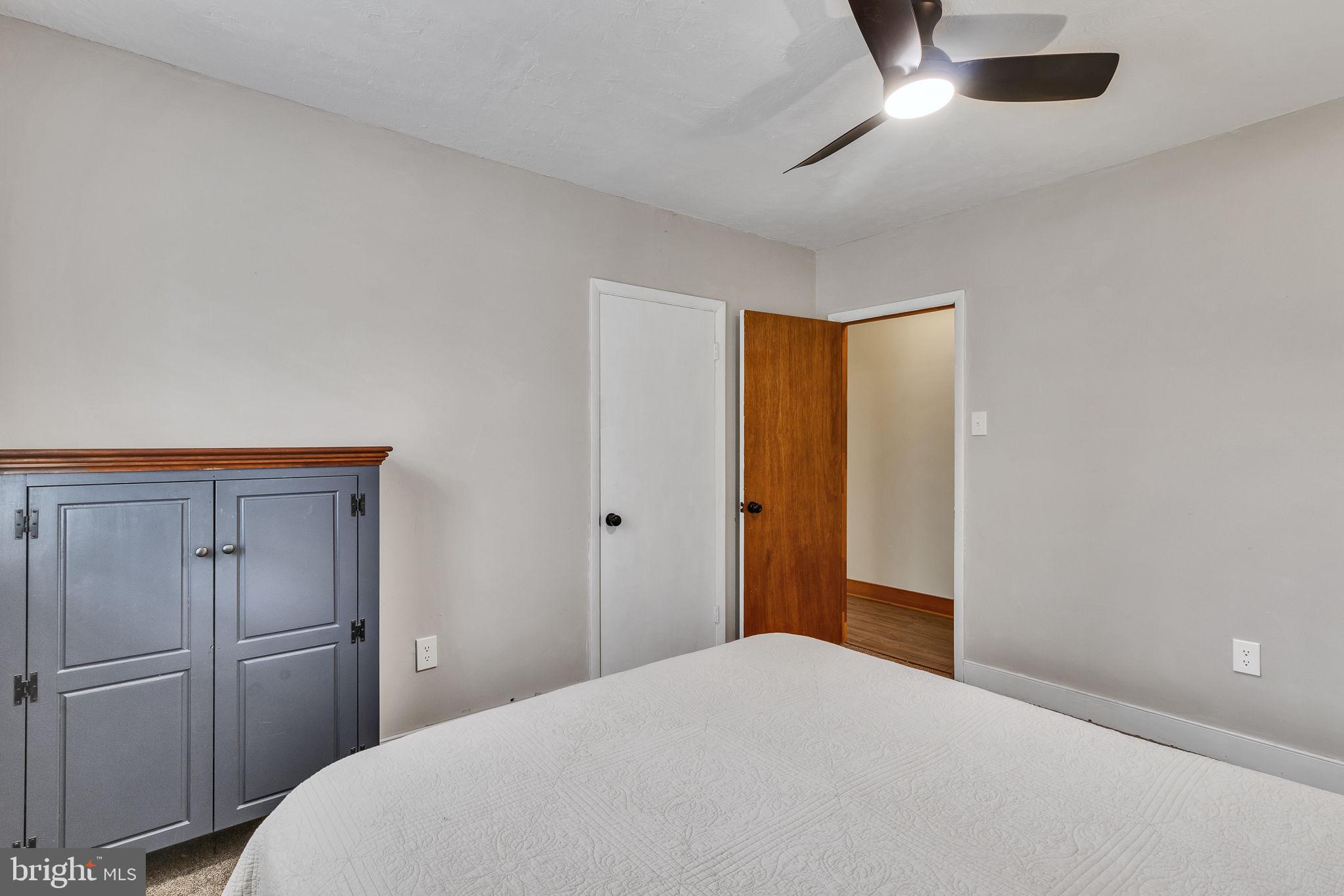 239 Lane Road Reedville, VA 22539 - Photo 26 of 61 a bedroom with a bed and a chandelier fan