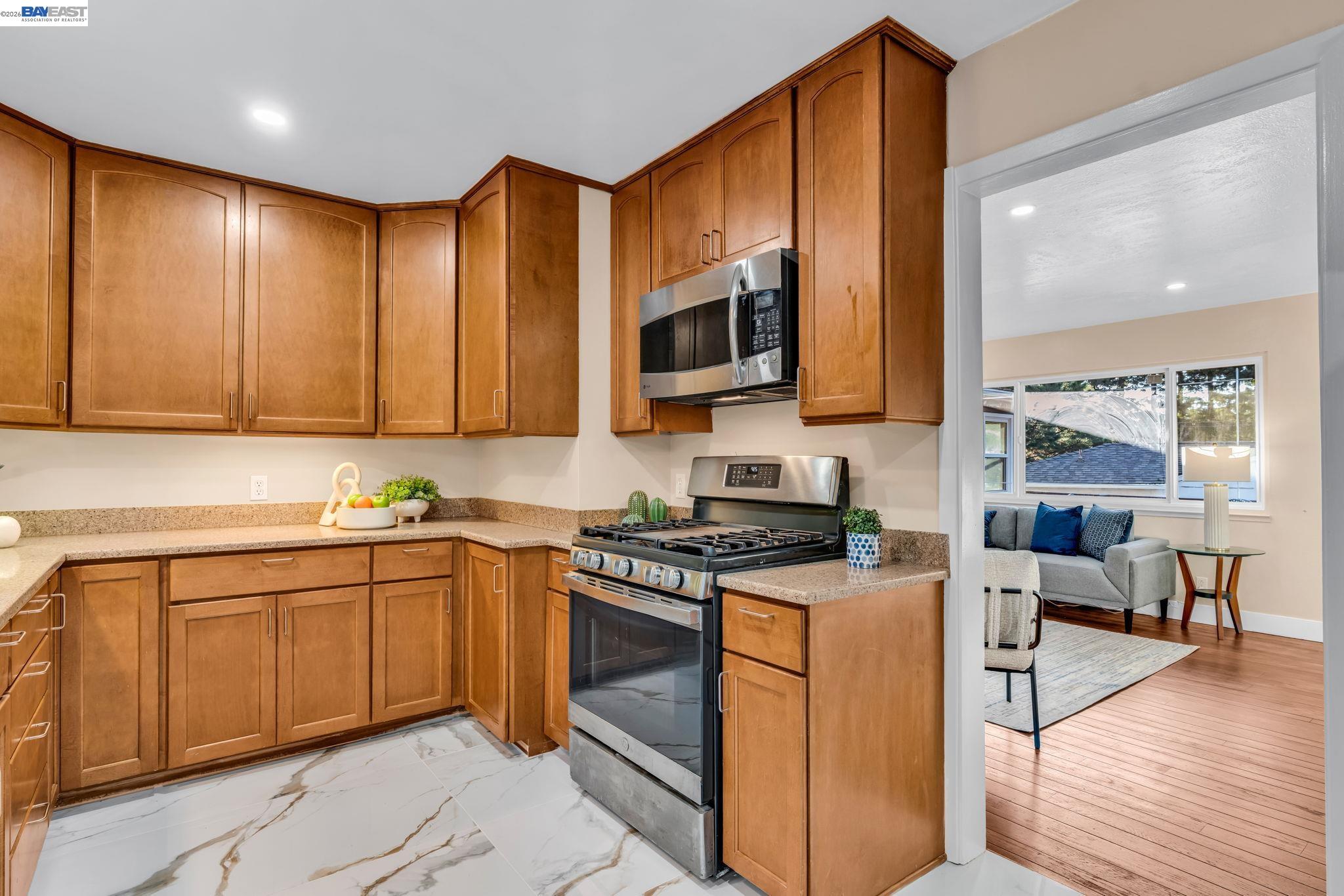 4628 Fieldbrook Road Oakland, CA 94619 - Photo 19 of 40 a kitchen with stainless steel appliances granite countertop wooden cabinets a stove a sink and a microwave