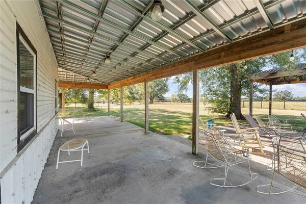 a view of a patio with a table chairs and wooden fence