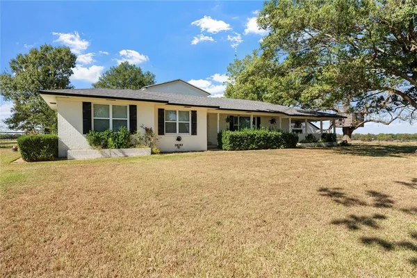 a front view of house with yard and trees around