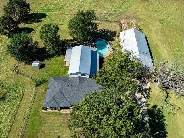 an aerial view of a house with a yard and lake view