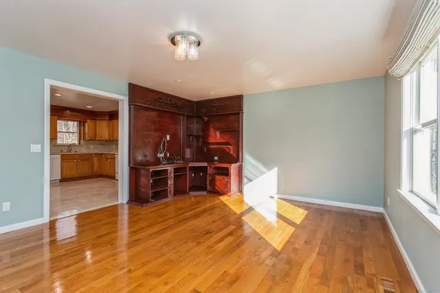 a view of empty room with wooden floor and cabinet