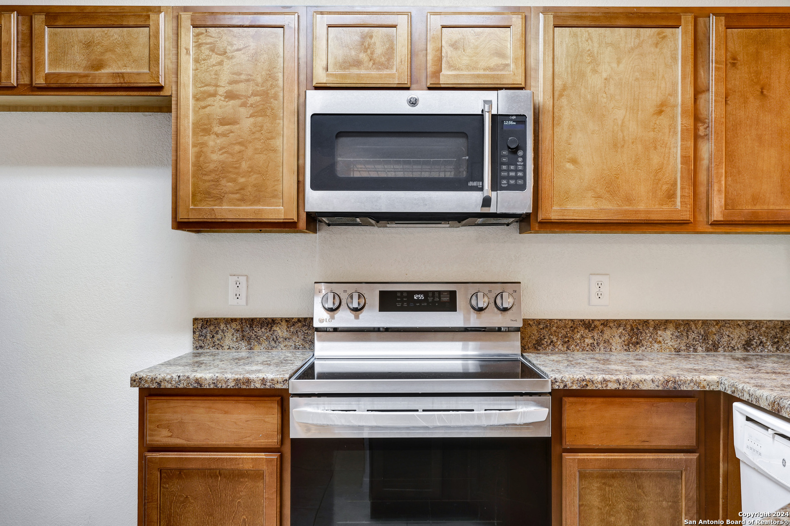 7323 Snowden Road, Unit 3108 San Antonio, TX 78229 - Photo 17 of 31 a kitchen with granite countertop a stove top oven microwave and cabinets