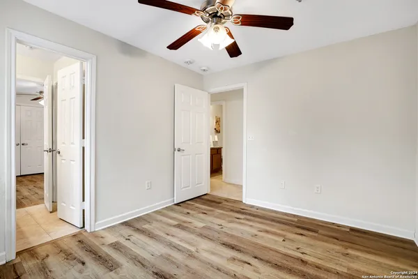 a view of a room with wooden floor and a ceiling fan