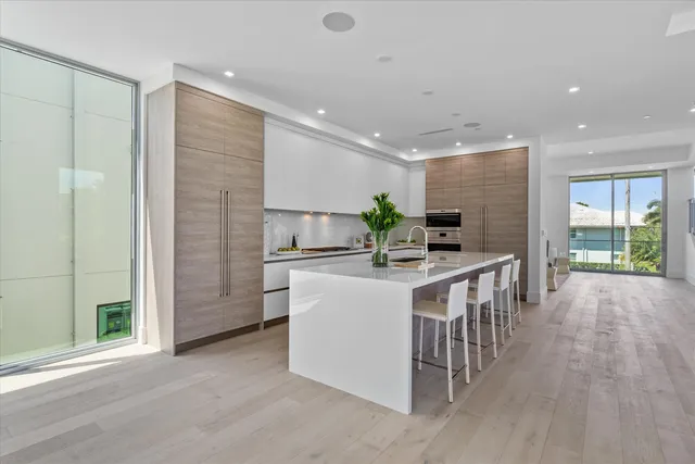 a kitchen with kitchen island a sink a stove a refrigerator and a cabinets
