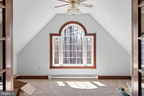 a view of a hallway with wooden floor and living room