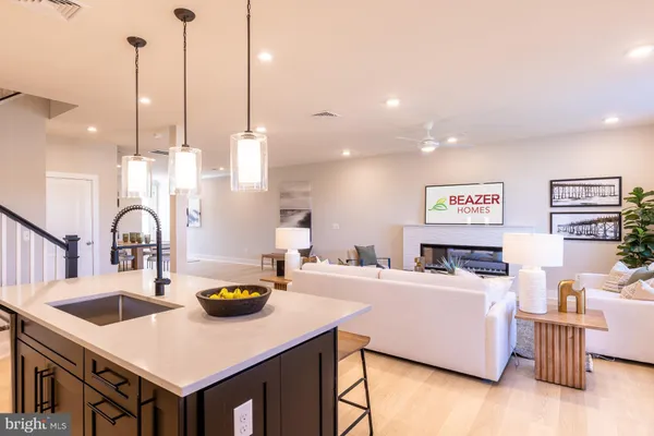 a kitchen with stainless steel appliances kitchen island a white counter space a sink and living room view