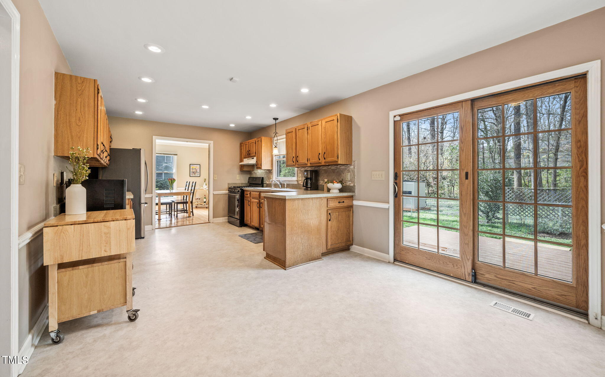 2415 Tryon Road Durham, NC 27705 - Photo 12 of 39 a view of kitchen with stainless steel appliances granite countertop a stove top oven a sink and a refrigerator