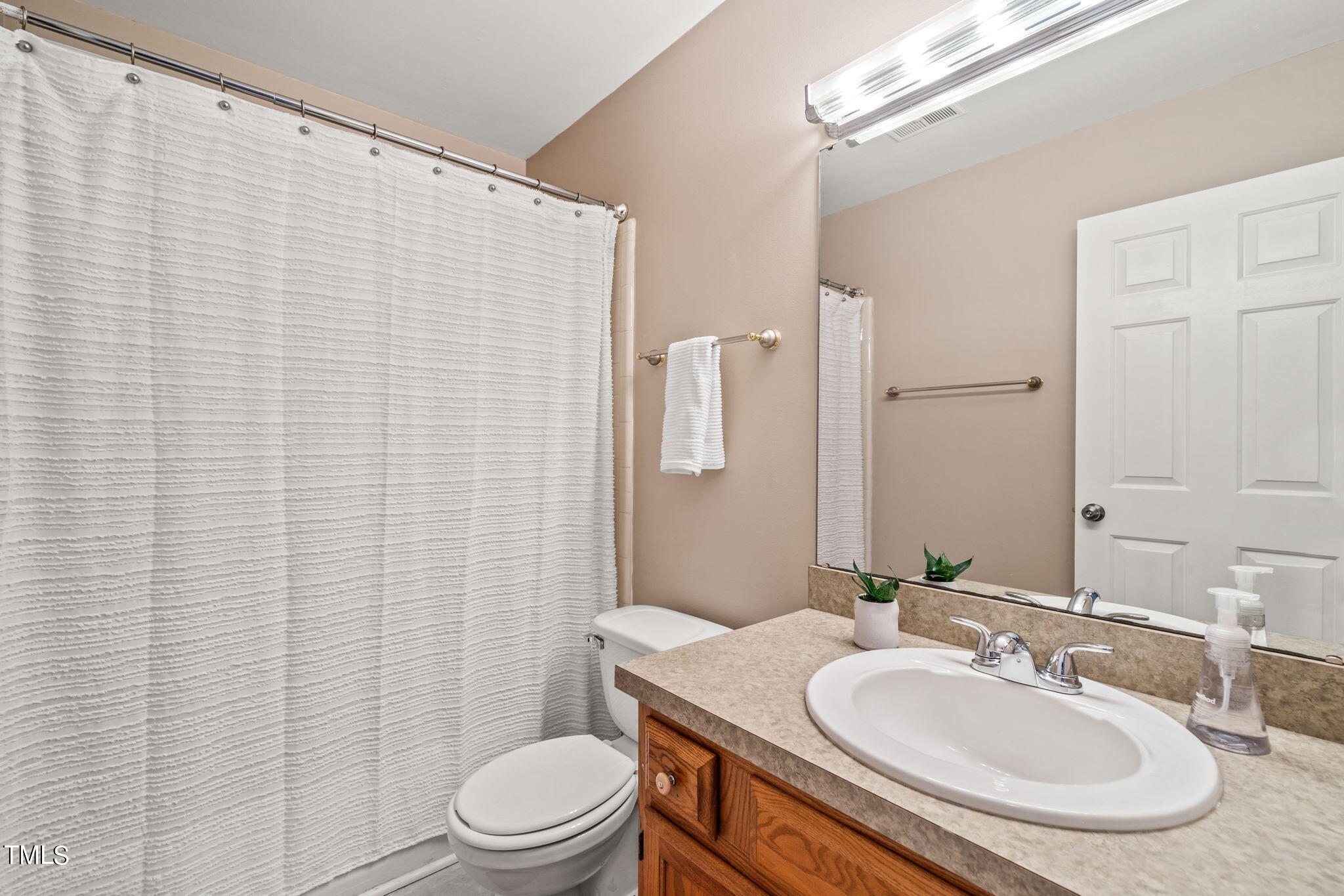2415 Tryon Road Durham, NC 27705 - Photo 30 of 39 a bathroom with a sink a toilet and shower curtain