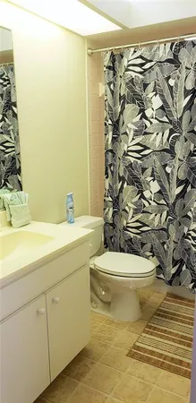 a bathroom with a toilet and shower curtain