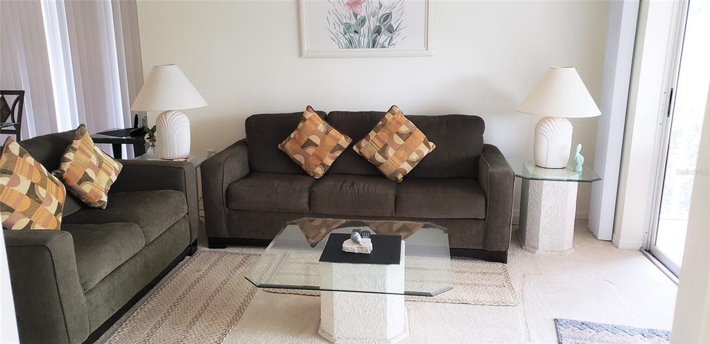 5678 Sheffield Greene Circle, Unit 76 Sarasota, FL 34235 - Photo 7 of 15 a living room with furniture and a lamp