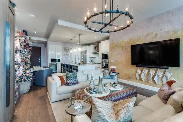 a living room with furniture a flat screen tv and a chandelier