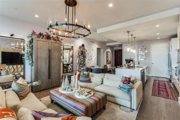 a living room with furniture kitchen view and a chandelier
