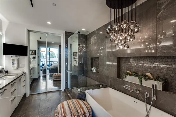 a spacious bathroom with a tub a double vanity sink a mirror and shower