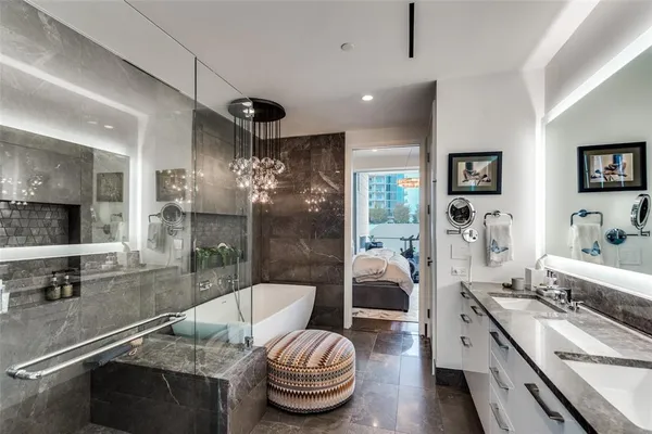 a bathroom with a granite countertop sink a toilet a mirror and shower