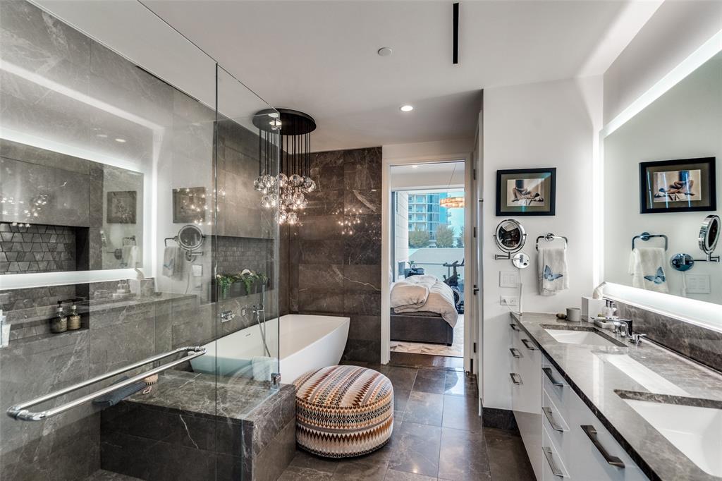 7901 Windrose Avenue, Unit 702 Plano, TX 75024 - Photo 21 of 40 a bathroom with a granite countertop sink a toilet a mirror and shower