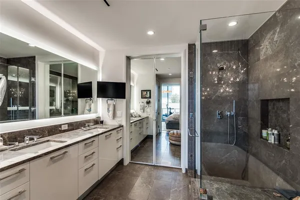 a large white bathroom with a granite countertop sink mirror and shower