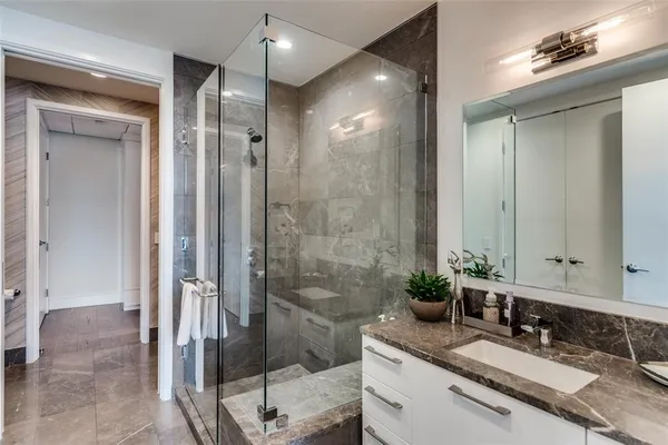 a bathroom with a granite countertop sink mirror and shower