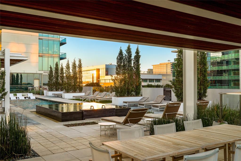 7901 Windrose Avenue, Unit 702 Plano, TX 75024 - Photo 33 of 40 a living room with couches a table and chairs with potted plants