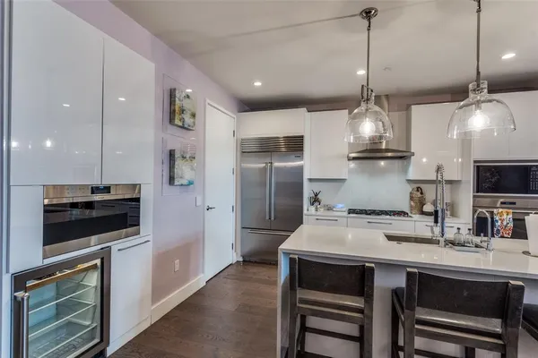 a kitchen with kitchen island a sink appliances and cabinets