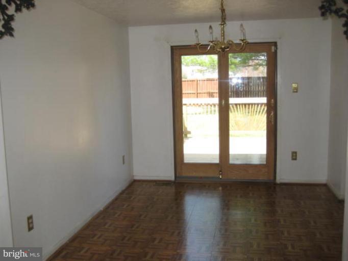 7928 Chipper Road Windsor Mill, MD 21244 - Photo 3 of 5 an empty room with wooden floor and windows
