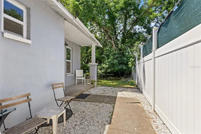 a view of a patio with table and chairs and wooden fence