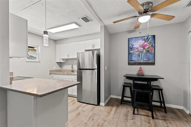 a kitchen with refrigerator cabinets and wooden floor