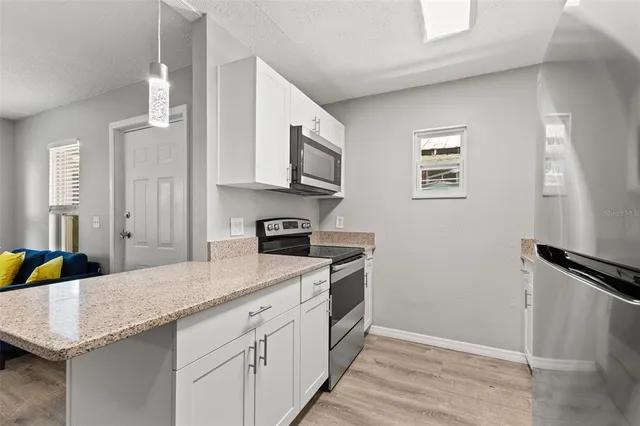 a kitchen with granite countertop a sink stove and cabinets