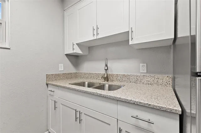 a kitchen with granite countertop a sink and cabinets