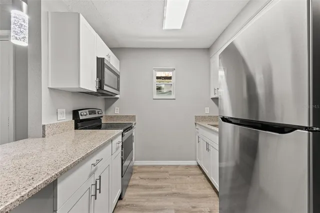 a kitchen with a refrigerator a sink and cabinets