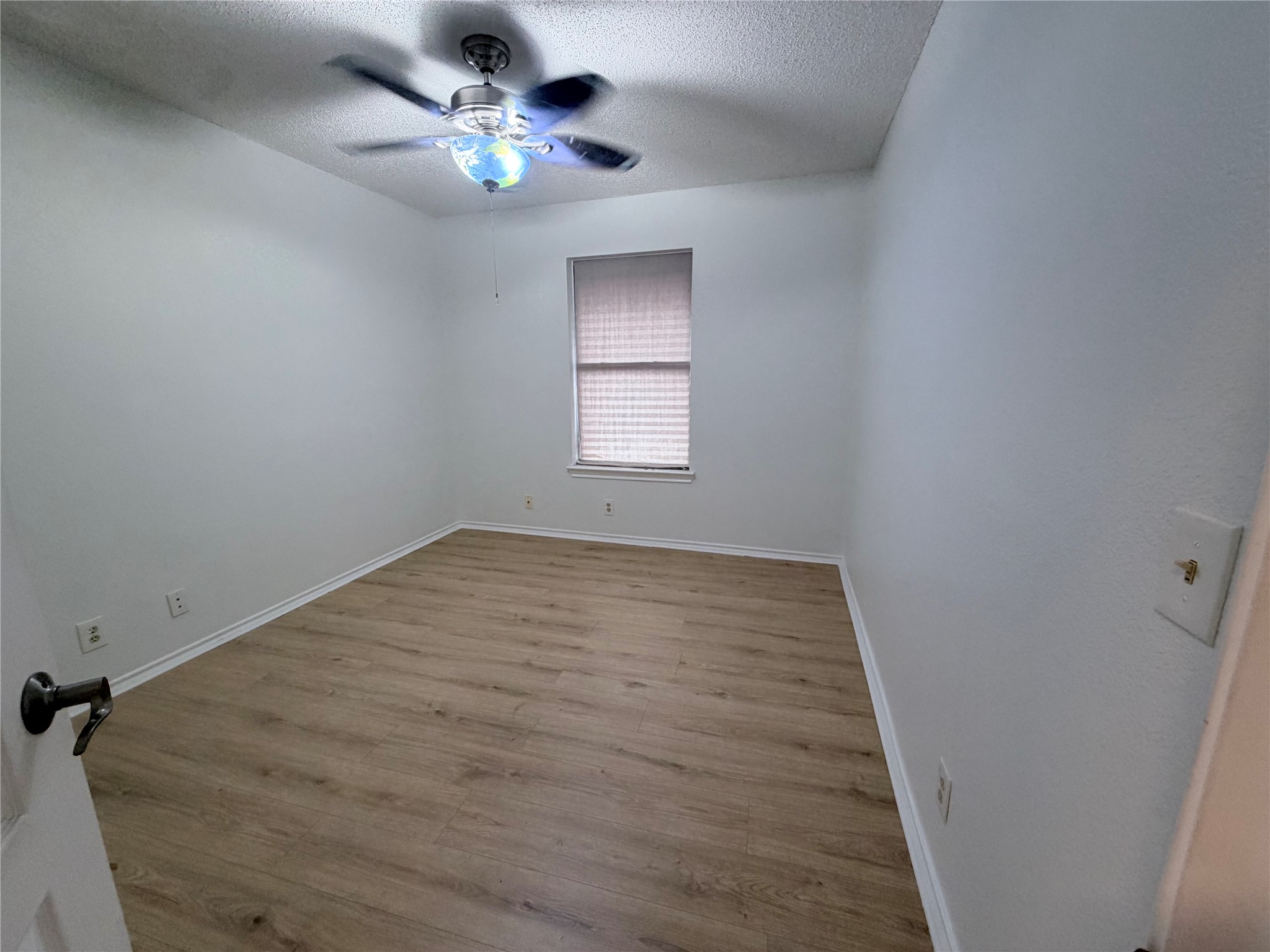 20809 Pacers Gait Lane Pflugerville, TX 78660 - Photo 6 of 23 Unfurnished room with wood finished floors, a textured ceiling, and a ceiling fan
