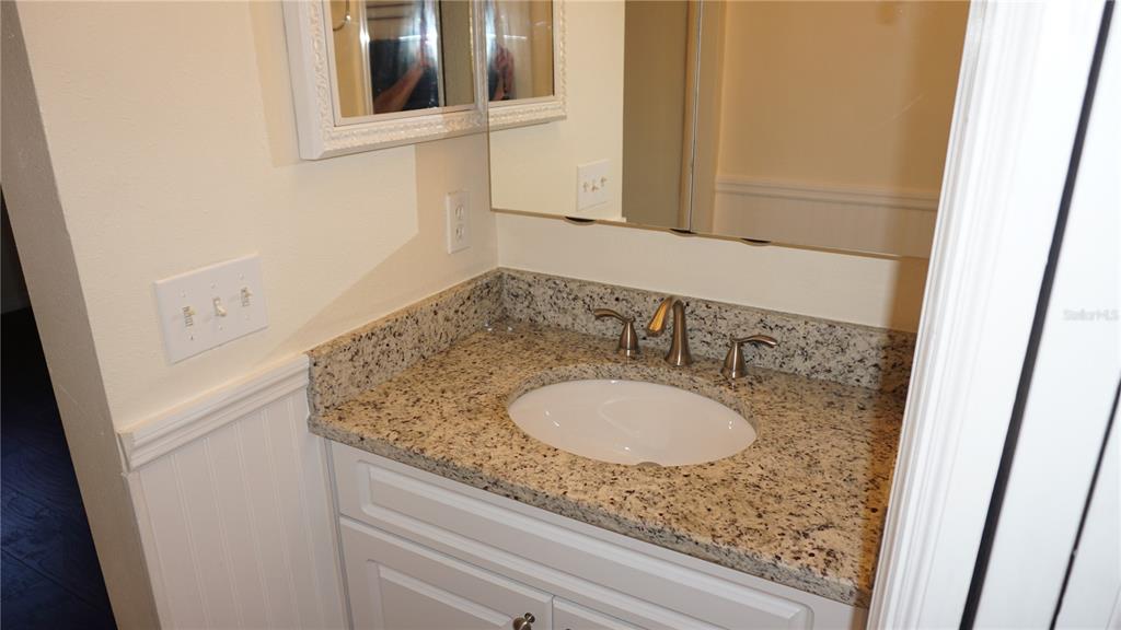 7602 Danube Drive, Unit 7602 Hudson, FL 34667 - Photo 13 of 31 a bathroom with a granite countertop sink and a mirror