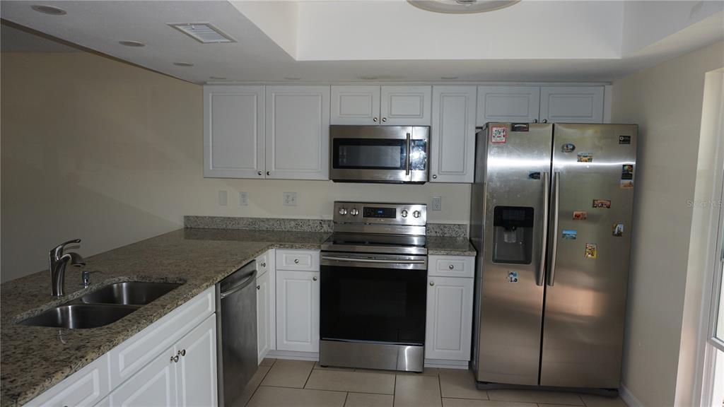 7602 Danube Drive, Unit 7602 Hudson, FL 34667 - Photo 3 of 31 a kitchen with granite countertop a refrigerator and a sink